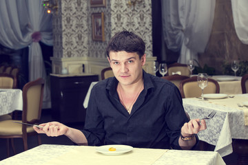 young man having dinner in a restaurant