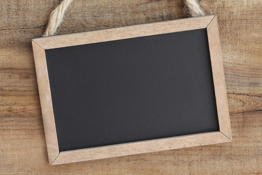 Fototapeta Vintage blackboard hanging on a wooden background