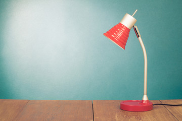 Retro red desk lamp on wooden table