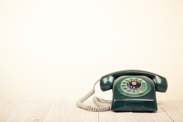 Retro green telephone on wooden table