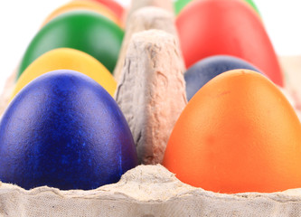 Cardboard egg box with colorful eggs.