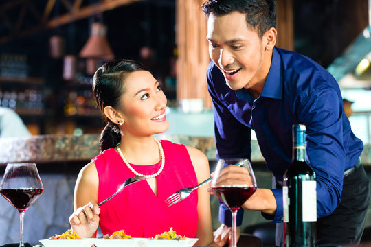 Portrait of Asian couple eating in restaurant