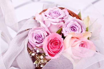 pink roses in brown basket with withe bow