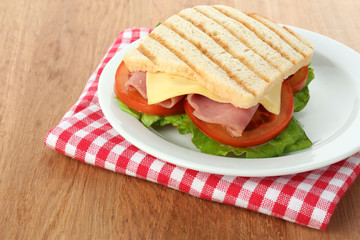 Tasty sandwich with ham on wooden table