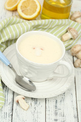 Delicate mushroom sauce in cup on wooden table close-up