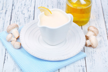 Delicate mushroom sauce in pitcher on wooden table close-up