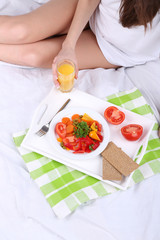 Obraz na płótnie Canvas Woman in bed with light breakfast