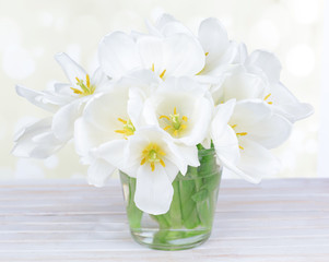 Beautiful bouquet of white tulips on table on light background
