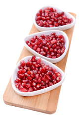 Ripe pomegranate in bowls isolated on white