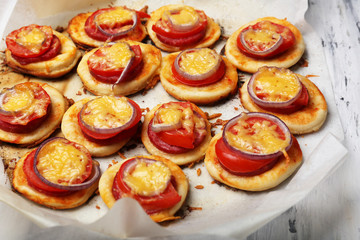 Small pizzas on baking paper close up