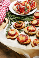 Small pizzas on baking paper close up