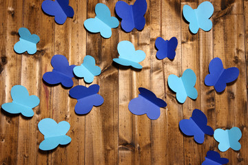 Paper cut out butterflies, on wooden background