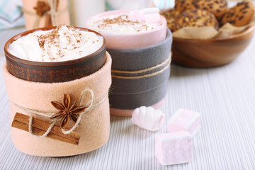 Mug of hot drink decorated in felt on wooden table