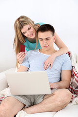 Fototapeta premium Loving couple sitting with laptop and credit card