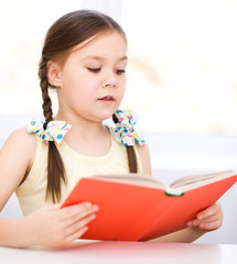 Little girl is reading a book