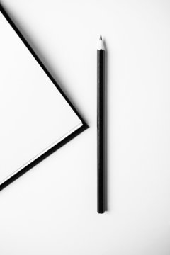 Closeup Of Book And Pencil On White Desk. Copy Space.