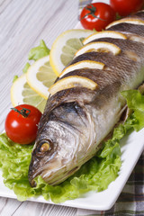 Baked sea bass with lemon, lettuce and cherry tomatoes