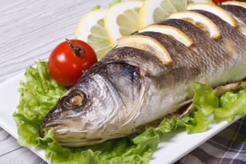 grilled sea bass with lemon, lettuce and tomatoes horizontal