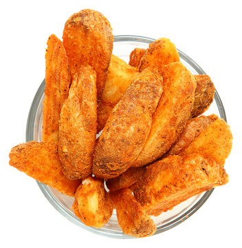 Spicy Potato Wedges in Glass Bowl Over White