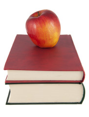 Red apple on top of a stack of books on white background