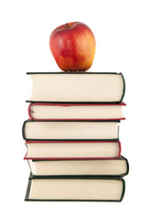 Red apple on top of a stack of books on white background