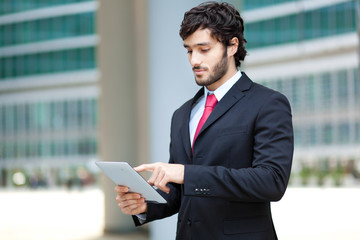 Fototapeta premium Handsome businessman using a tablet