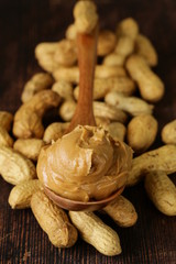 peanut butter in a wooden spoon with whole nuts