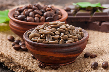 Green and brown coffee beans in bowls