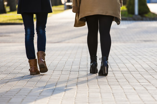 Young women walking on the sidewalk.