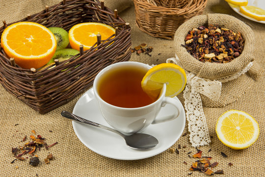 Hot cup of tea, herbal leaves and ripe fruits
