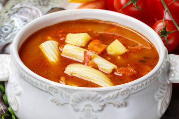 Bowl of tomato soup on wooden table