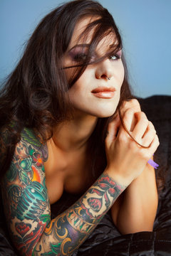 Beautiful girl with stylish make-up and tattooed arms,..