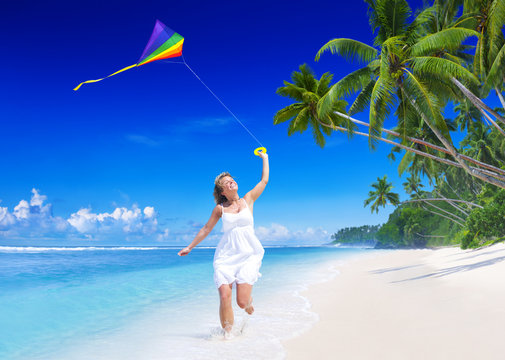 Woman Flying A Kite On The Beach