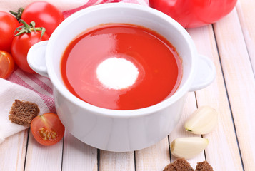 Tasty tomato soup and vegetables on wooden table