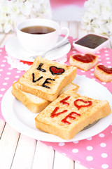Delicious toast with jam and cup of tea on table close-up