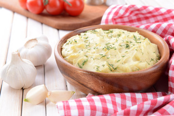 Delicious mashed potatoes with greens in bowl on table close-up