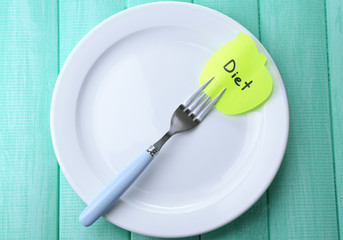 Note paper with message  attached to fork,