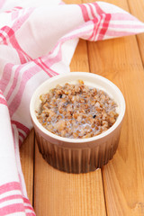 Boiled buckwheat with milk in bowl on table close-up