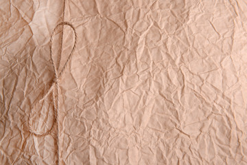 String tied in  bow on beige paper packaging close-up