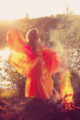 Obraz na płótnie Canvas Beauty witch in the woods near the fire. Magic woman celebrating