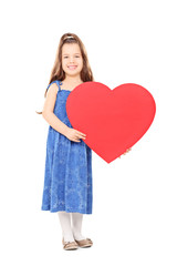 Little girl holding a big red heart