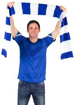 Football fan in blue holding scarf