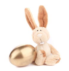 Obraz premium White toy rabbit with golden egg.