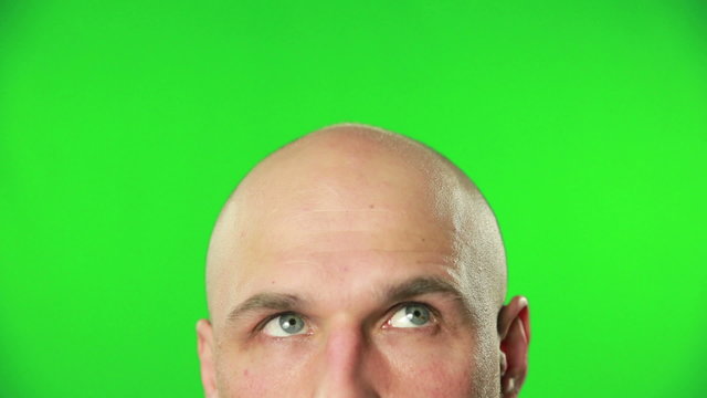 Close up of male head and eyes against a green screen