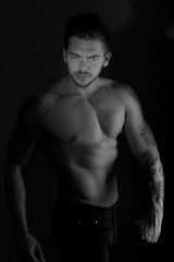 Fototapeta na wymiar muscular man shot in dark background