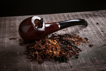 pipe and tobacco on wooden surface