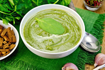 Puree green with spinach and croutons on board