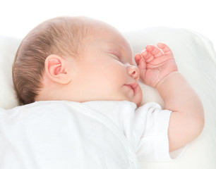 New born infant child baby girl sleeping on a back in white shir