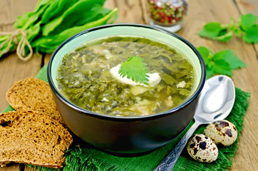 Soup green sorrel and nettles with a spoon on board
