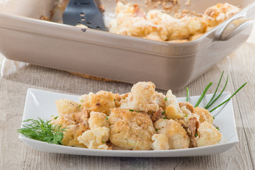 Cavolfiore gratinato con tonno servito su un piatto  bianco